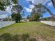 Expansive grassy backyard featuring mature trees and a charming single-story home in a serene setting at 1280 Thornton Ct, Spring Hill, FL 34608