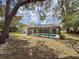 A large, shaded backyard with a private screened pool at 1280 Thornton Ct, Spring Hill, FL 34608