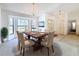 Elegant dining room with a wooden table, upholstered chairs, chandelier, and a bright bay window at 1280 Thornton Ct, Spring Hill, FL 34608