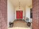 Inviting front entrance featuring a red double door, tiled floor, potted plants, and decorative lighting at 1280 Thornton Ct, Spring Hill, FL 34608