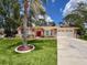 Charming one-story home with a bright red front door, mature landscaping, and an expansive driveway at 1280 Thornton Ct, Spring Hill, FL 34608