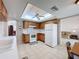 Functional kitchen featuring wooden cabinets, white appliances, tile flooring, and ample counter space at 1280 Thornton Ct, Spring Hill, FL 34608