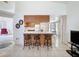 Well-lit kitchen with barstool seating, wood cabinets, white appliances, and easy access to other rooms at 1280 Thornton Ct, Spring Hill, FL 34608