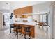 Open-concept kitchen and dining area features wood cabinets, barstool seating, and sliding door access to outdoors at 1280 Thornton Ct, Spring Hill, FL 34608
