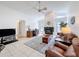 Bright living room featuring a fireplace, ceiling fan, office desk, and cozy leather seating at 1280 Thornton Ct, Spring Hill, FL 34608