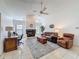 Well-lit living room with fireplace, ceiling fan, tile floors, and comfortable seating arrangement at 1280 Thornton Ct, Spring Hill, FL 34608