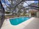 Relax and unwind in the privacy of the screened-in pool, with views of the landscaped backyard at 1280 Thornton Ct, Spring Hill, FL 34608