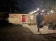 Night view of a backyard featuring a pergola with ambient lighting, a cozy seating area, and a relaxing hammock at 1309 45Th S St, St Petersburg, FL 33711