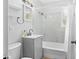 Well-lit bathroom featuring white marble tile surround, gray vanity, and shower-tub combination at 1309 45Th S St, St Petersburg, FL 33711