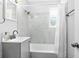 Well-lit bathroom featuring white marble tile surround, gray vanity, and shower-tub combination at 1309 45Th S St, St Petersburg, FL 33711