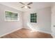 A bright bedroom has two windows, wood-look floors, and a ceiling fan at 1309 45Th S St, St Petersburg, FL 33711