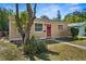 Charming single story home with a red front door, a well-manicured lawn, and mature landscaping at 1309 45Th S St, St Petersburg, FL 33711