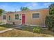Charming single story home with a red front door, a well-manicured lawn, and mature landscaping at 1309 45Th S St, St Petersburg, FL 33711