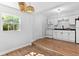Stylish kitchen featuring white cabinets, modern appliances, and trendy pendant lighting, open to the adjacent dining area at 1309 45Th S St, St Petersburg, FL 33711