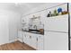 Contemporary kitchen with white cabinets, stainless appliances, black countertops, and modern fixtures at 1309 45Th S St, St Petersburg, FL 33711