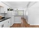 Modern kitchen with white cabinets and appliances, featuring sleek countertops and wood-look flooring at 1309 45Th S St, St Petersburg, FL 33711