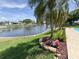 Backyard with canal, fencing, and manicured landscaping with garden art at 1412 Linstock Dr, Holiday, FL 34690