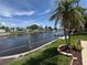 Scenic backyard featuring waterfront views, lush landscaping, and swaying palm trees at 1412 Linstock Dr, Holiday, FL 34690