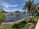 Scenic backyard featuring waterfront views, lush landscaping, and swaying palm trees at 1412 Linstock Dr, Holiday, FL 34690