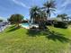 Backyard with pool, porch, patio, tropical plants, lawn, garden, canal, and fencing at 1412 Linstock Dr, Holiday, FL 34690