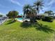 Backyard with pool, garden, canal, tropical landscaping, lawn, and fencing at 1412 Linstock Dr, Holiday, FL 34690