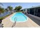 The private backyard features a sparkling pool, patio area, and access to the scenic canal and waterfront at 1412 Linstock Dr, Holiday, FL 34690