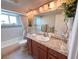 Bathroom features stylish vanity, updated lighting, and bathtub with shower at 1412 Linstock Dr, Holiday, FL 34690