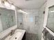 Beautiful bathroom features white-tiled shower with glass door and pebble-style shower floor at 1412 Linstock Dr, Holiday, FL 34690