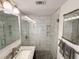 Beautiful bathroom features white-tiled shower with glass door and pebble-style shower floor at 1412 Linstock Dr, Holiday, FL 34690