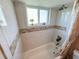 Well-lit bathroom features ceramic tile surround, updated fixtures, and a decorative floral arrangement at 1412 Linstock Dr, Holiday, FL 34690