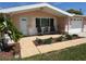 Welcoming front patio area with seating, lush landscaping, and decorative walkway to the entrance at 1412 Linstock Dr, Holiday, FL 34690