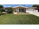 Inviting home exterior with well-maintained lawn and walkway leading to the front entrance and seating at 1412 Linstock Dr, Holiday, FL 34690
