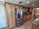 Well-equipped kitchen featuring stainless steel fridge and complementary wood cabinetry at 1412 Linstock Dr, Holiday, FL 34690