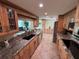 Open kitchen with granite countertops, wood cabinets, black sink, and stainless steel dishwasher at 1412 Linstock Dr, Holiday, FL 34690