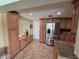Beautiful kitchen featuring stainless steel fridge, wood cabinets, and tile floors at 1412 Linstock Dr, Holiday, FL 34690