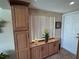 Bright kitchen featuring built-in cabinets, tile floors, and view of the doorway at 1412 Linstock Dr, Holiday, FL 34690