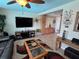 Cozy living room featuring tiled floors, a ceiling fan, and a view of the kitchen at 1412 Linstock Dr, Holiday, FL 34690