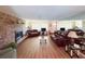 Bright living room with brick fireplace, laminate floors, and comfortable leather seating at 1412 Linstock Dr, Holiday, FL 34690