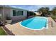 Backyard pool sits alongside the home's screened porch, with view of manicured lawn and landscaping at 1412 Linstock Dr, Holiday, FL 34690