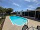 Backyard pool shows patio, a screened-in porch, and a well-maintained lawn in a sunny real estate image at 1412 Linstock Dr, Holiday, FL 34690