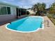 Pool with patio, porch, tropical landscaping, manicured lawn, and fencing at 1412 Linstock Dr, Holiday, FL 34690