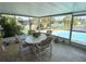 Enclosed sunroom features comfortable seating with views of the pool and surrounding landscape at 1412 Linstock Dr, Holiday, FL 34690