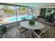 Enclosed sunroom features comfortable seating and views of the pool, canal, and lush landscaping at 1412 Linstock Dr, Holiday, FL 34690