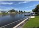 Beautiful waterfront view with backyard access to the canal and nearby boat docks under a partly cloudy blue sky at 1412 Linstock Dr, Holiday, FL 34690