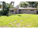 Exterior view of the backyard, showcasing the home's architecture and spacious lawn area at 1540 Lime St, Clearwater, FL 33756