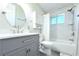 Updated bathroom with gray vanity, white tub, shower, and cabinet storage at 1540 Lime St, Clearwater, FL 33756