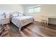 Serene bedroom featuring natural light, a cozy bed, and stylish wood-look flooring at 1540 Lime St, Clearwater, FL 33756