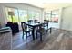 Well-lit dining room with large windows, a dark wood table and views of the lush backyard at 1540 Lime St, Clearwater, FL 33756