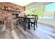 Open dining area with a brick fireplace, large windows with a pool view and hardwood flooring at 1540 Lime St, Clearwater, FL 33756