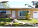 Close up front exterior featuring updated windows, neutral color palette, walkway, and well maintained lawn at 1540 Lime St, Clearwater, FL 33756